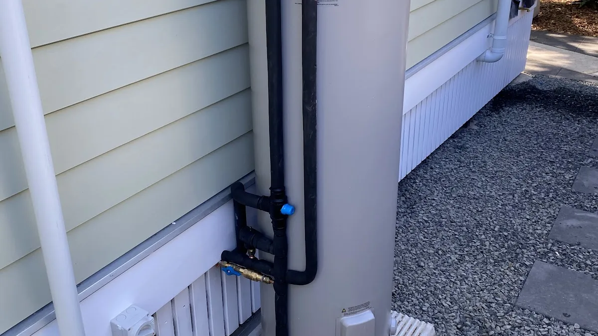 Close view of the lagged hot and cold pipes and valves on a new electric hot water system