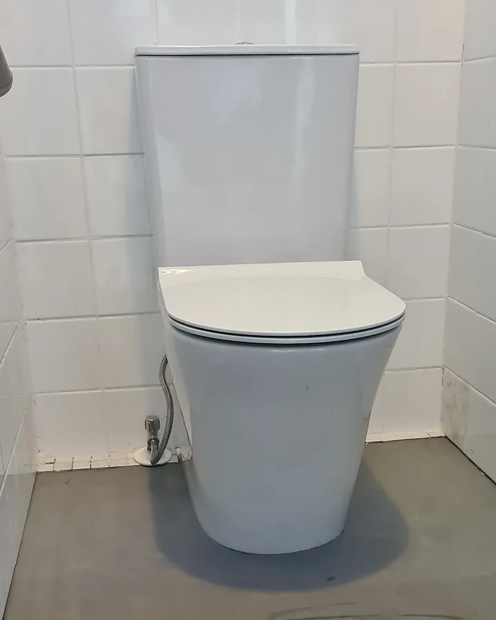 A new back-to-wall toilet suite installed by Right and Tight Plumbing in a white tiled room